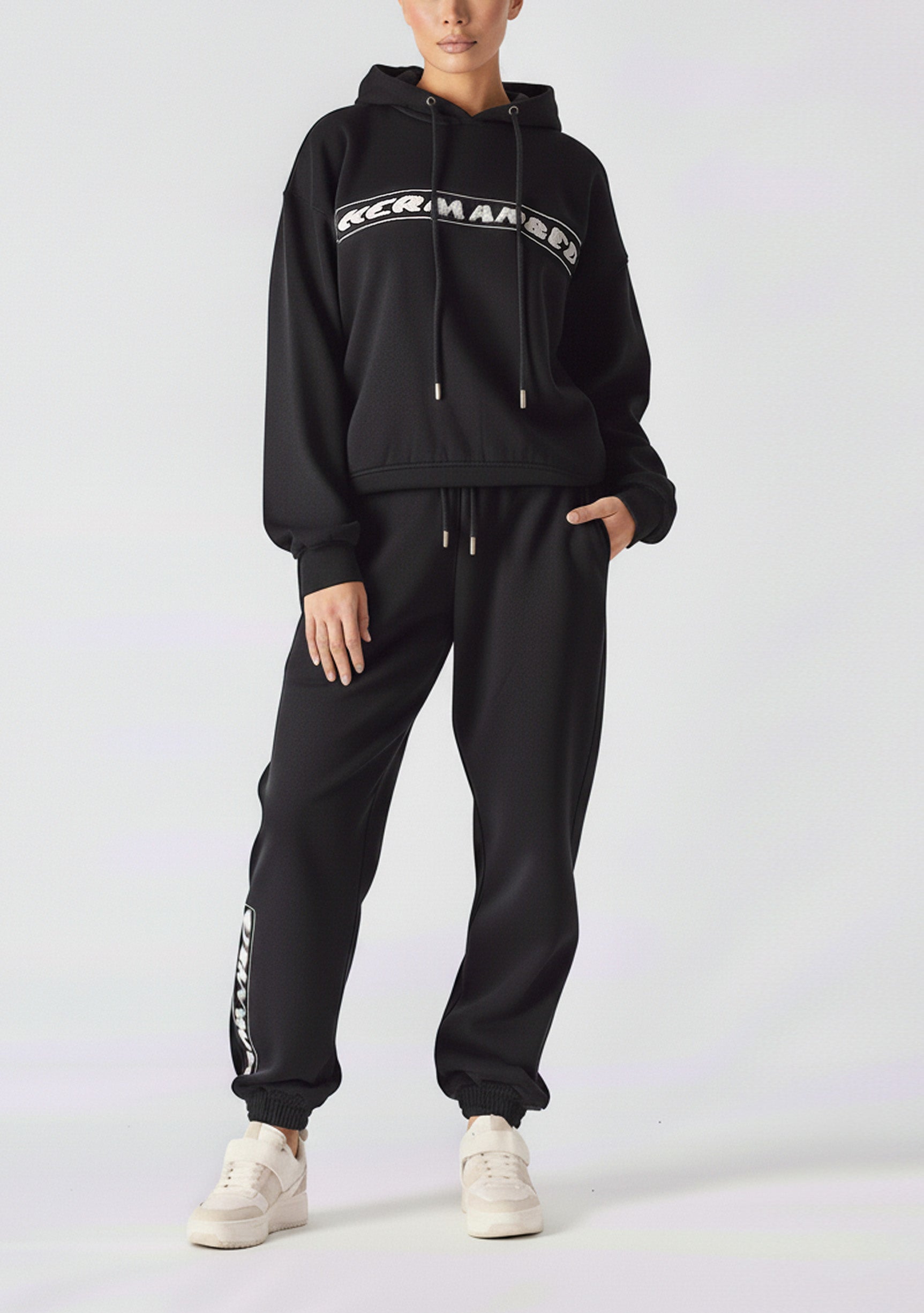 A woman wearing a stylish oversized hoodie black in a front view.