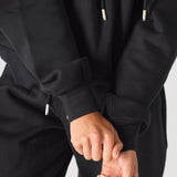 Close up of the premium brush back fabric and cuff on the oversized hoodie black.