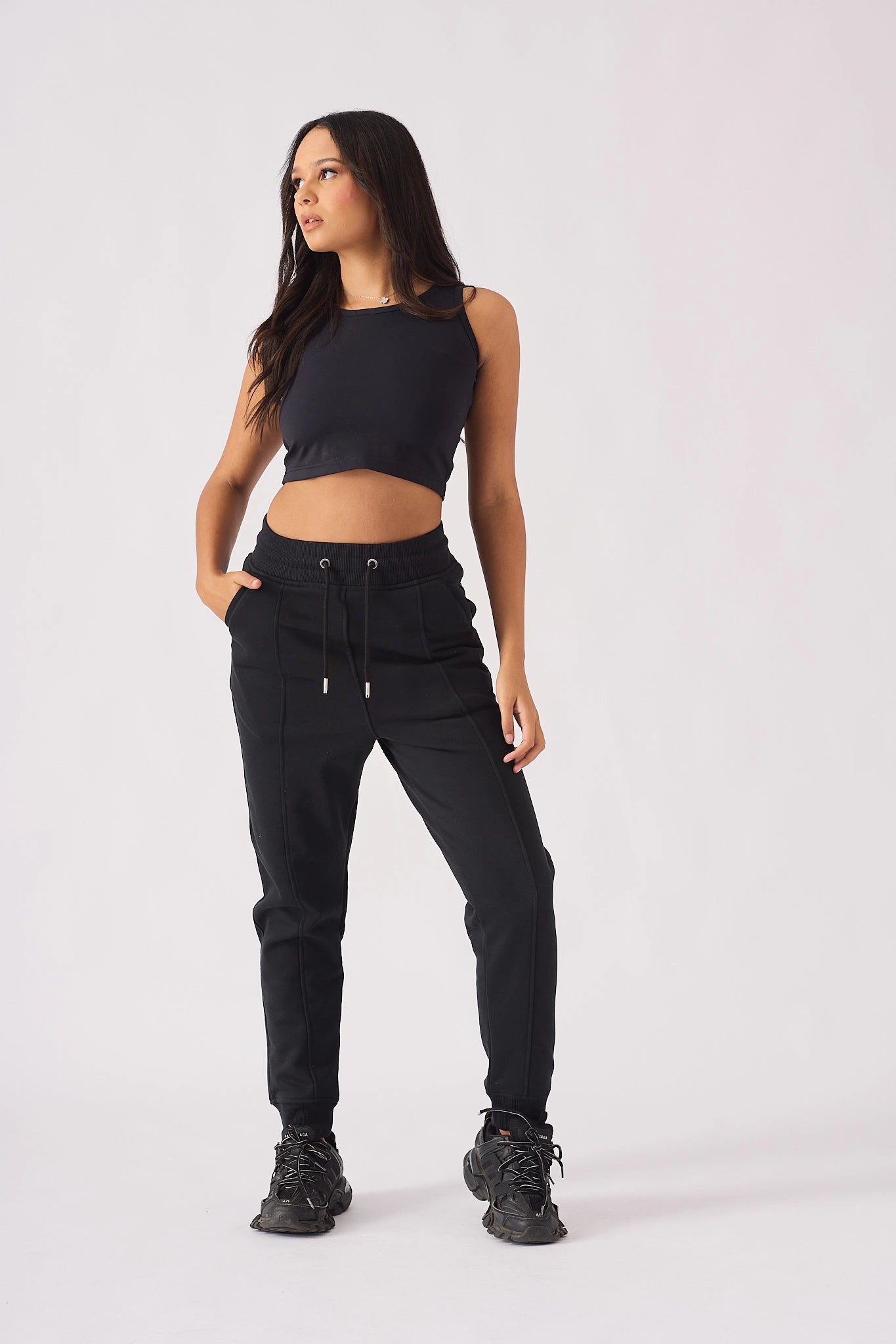Full length view of model wearing black pintuck jogger and crop top