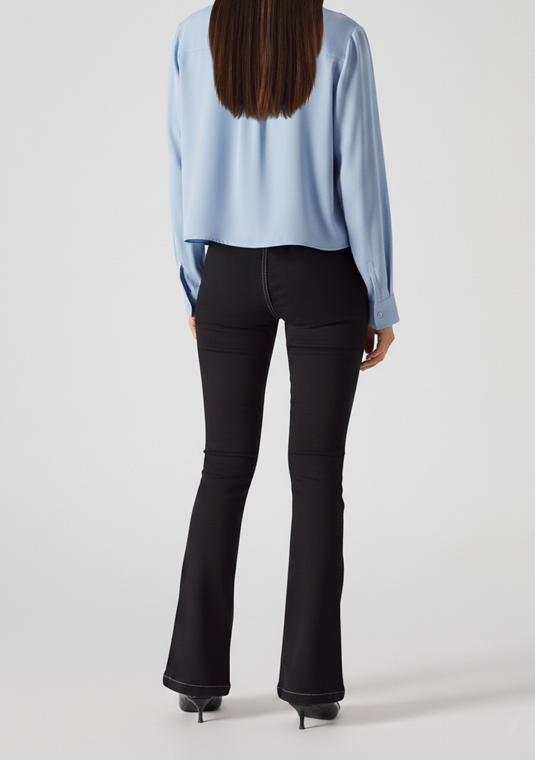 Full back view of model wearing charcoal grey high-waisted bootcut jeans featuring a clean back with no pockets.