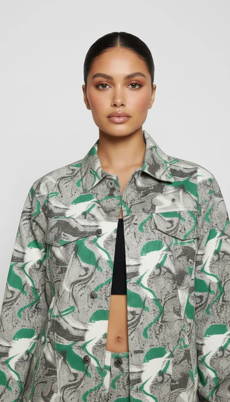 Upper body close up of psychedelic print denim jacket showing collar, placket, and chest pockets - women’s oversized abstract swirl patterned jacket over ribbed black top