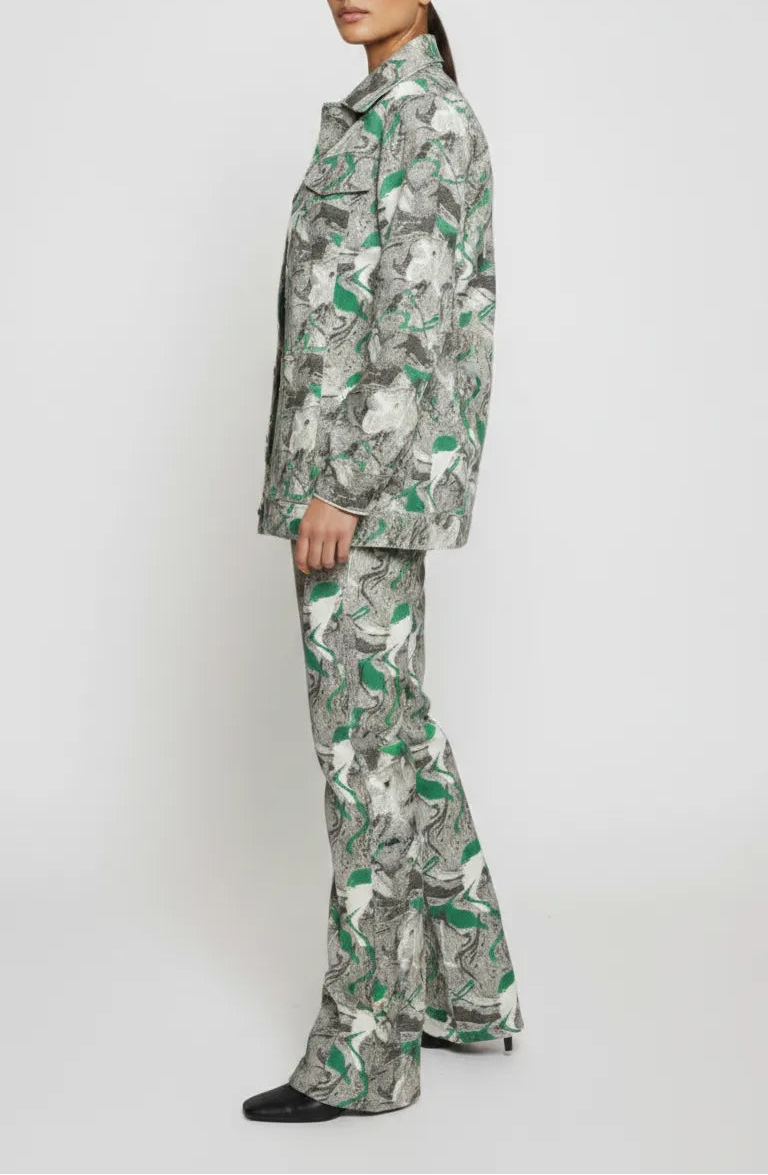 Side profile full length of psychedelic print denim jacket showing flared cargo pants silhouette - women’s green-grey abstract swirl two-piece set