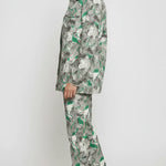 Side profile full length of psychedelic print denim jacket showing flared cargo pants silhouette - women’s green-grey abstract swirl two-piece set