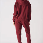 Back view of a model in the relaxed fit red zip up hoodie womens showing the hood.