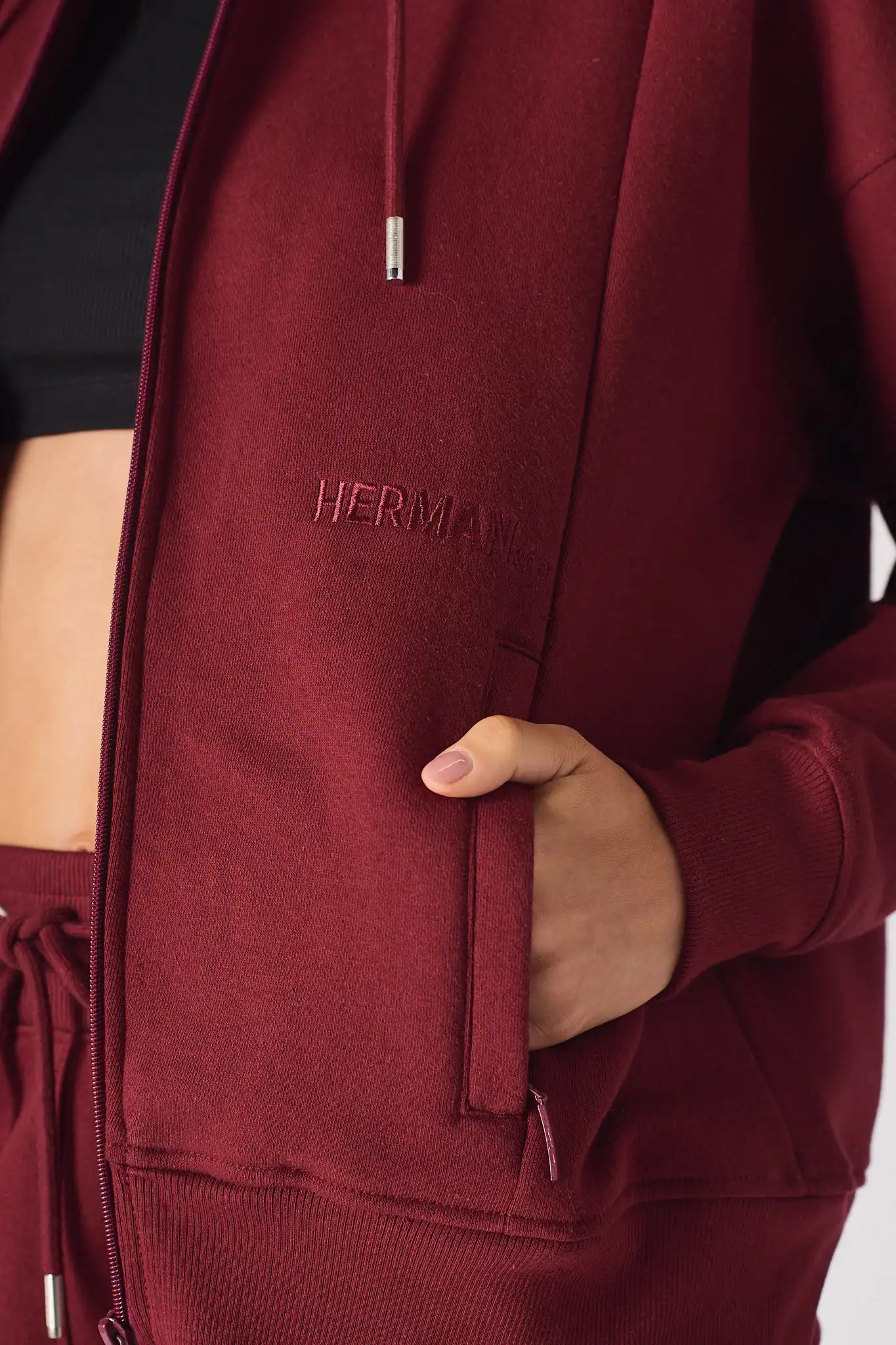 Close up detail of the tonal embroidery and pocket on the red zip up hoodie womens.