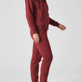 Side profile of a woman walking in the comfortable red zip up hoodie womens.