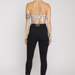 Person wearing a sheer top and black pants on a white background