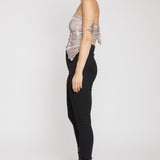 Person wearing a sheer top and black pants with high heels on a white background