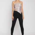 Person wearing a sheer top and black pants on a white background