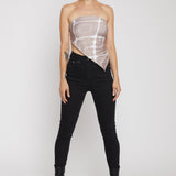 Person wearing a sheer top and black pants on a white background