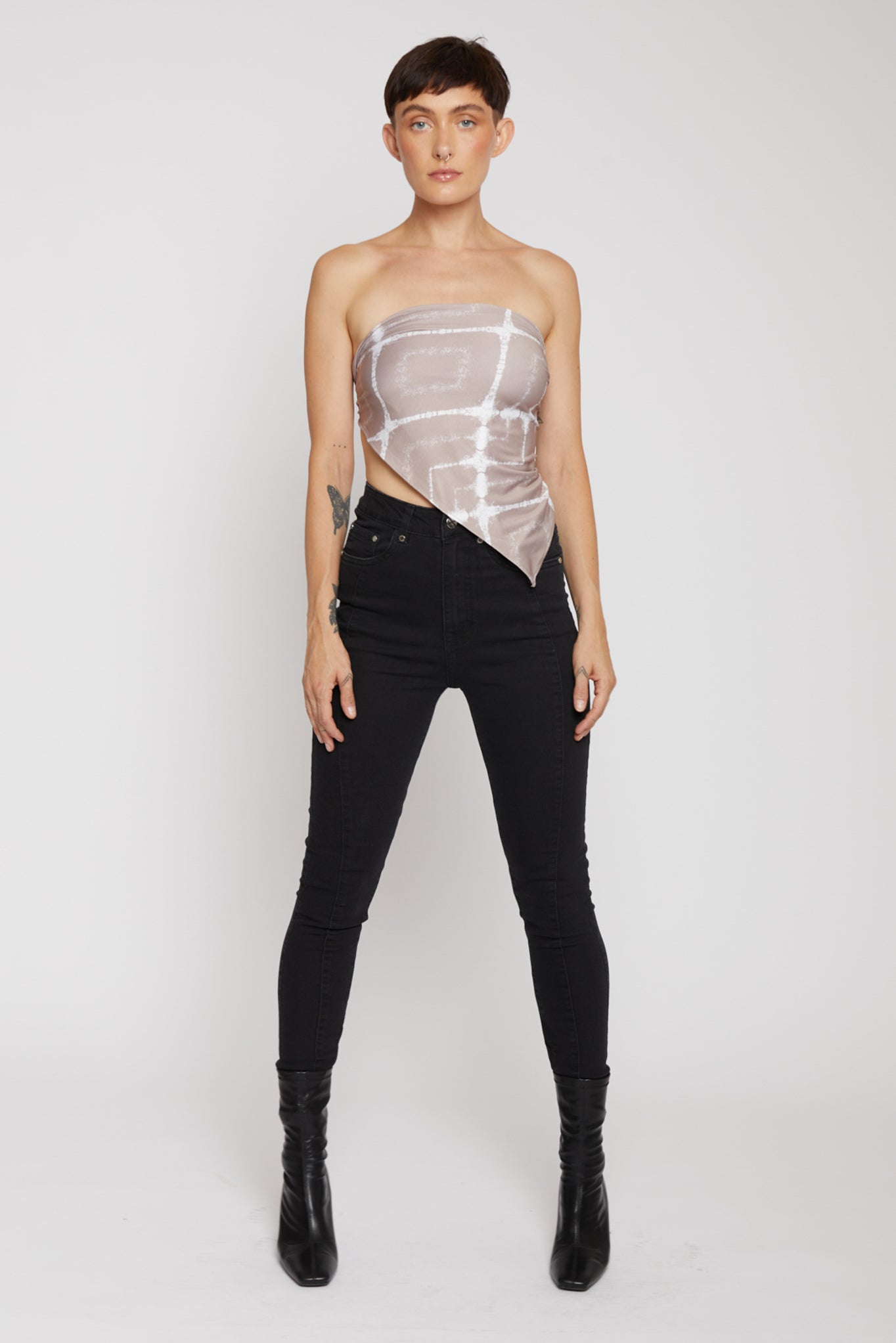 Person wearing a sheer top and black pants on a white background