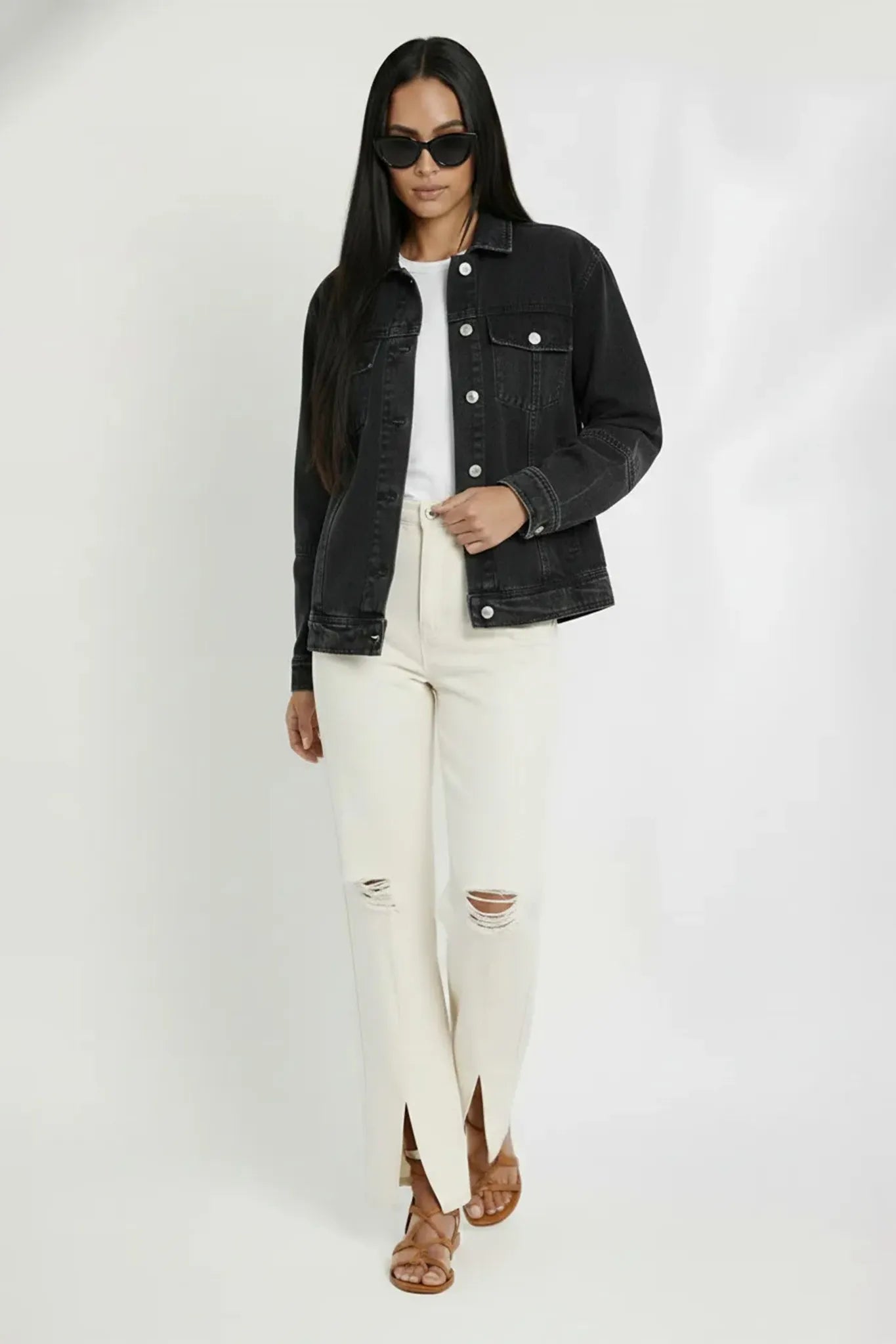 Front walking pose of women wearing soft black wash denim jacket with distressed white pants - relaxed fit vintage cotton trucker jacket streetwear