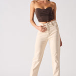 Woman wearing a strapless top and beige pants on a white background