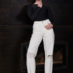 A model styled in the off-white distressed tapered jeans.