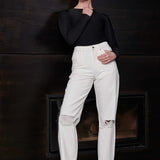 A model styled in the off-white distressed tapered jeans.