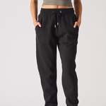 A model with hands in pockets wearing the tapered women's joggers in black