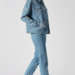 Side walking pose of mid wash tattoo print denim jacket with white embroidery - women’s matching cargo pants set featuring butterfly, rose, and compass motifs