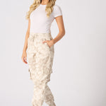 A woman walking in trendy beige tie dye cuffed cargo joggers