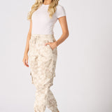 A woman walking in trendy beige tie dye cuffed cargo joggers