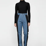 Model standing with arms crossed wearing two-shade high-waisted jeans.