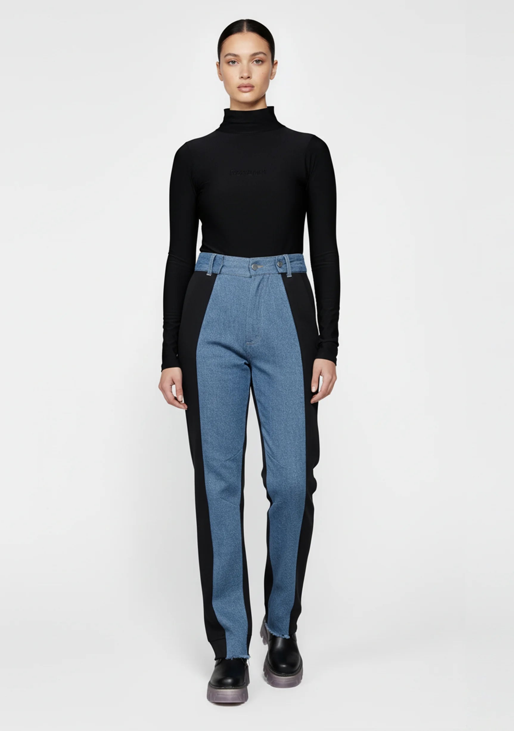 Model standing with arms crossed wearing two-shade high-waisted jeans.