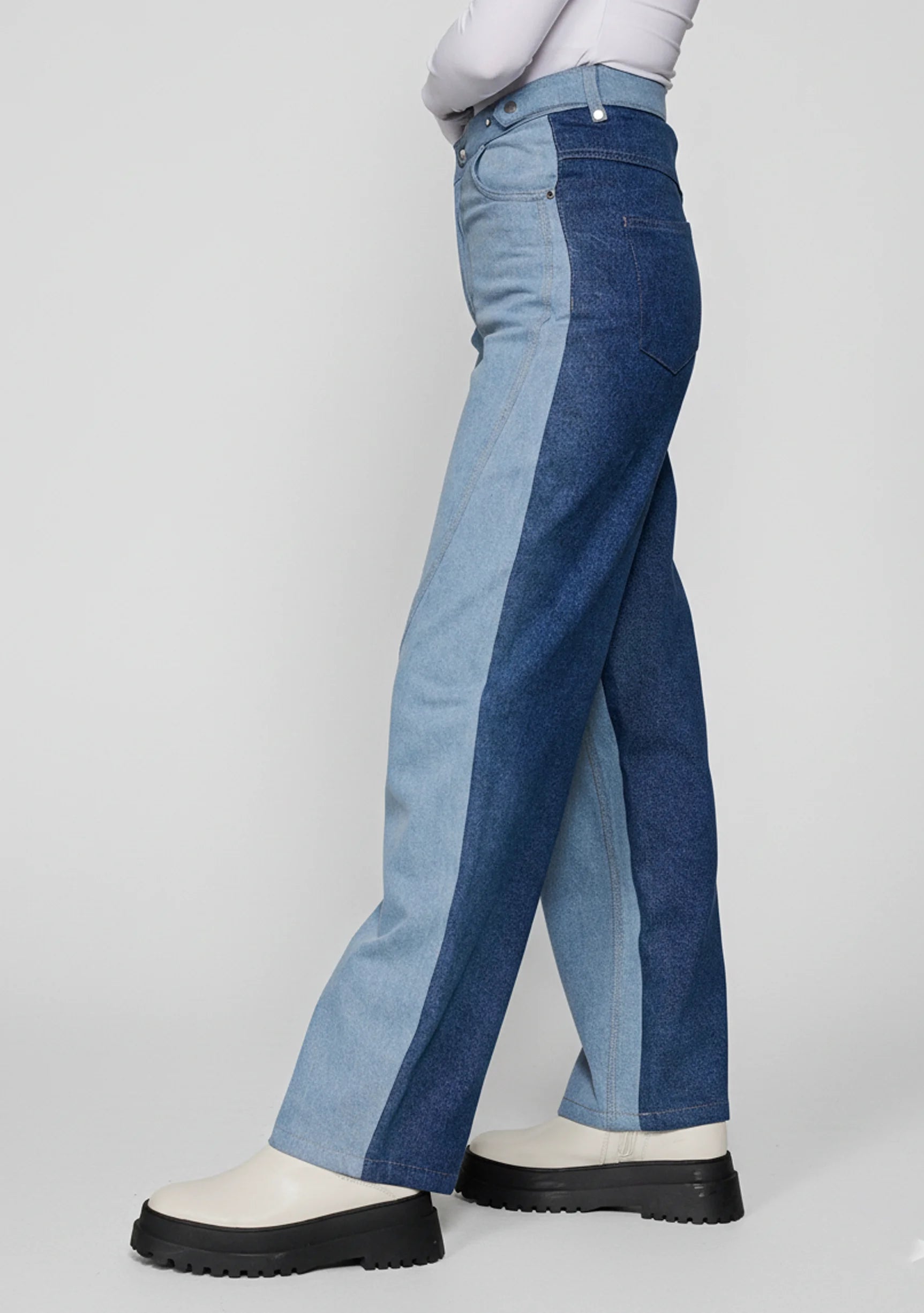 Side profile view of women's two-tone wide leg jeans showing light and dark blue denim