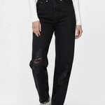 Person wearing black jeans and white sneakers on a white background