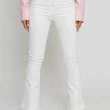Close up of the front pockets, button closure, and high waist on white jeans