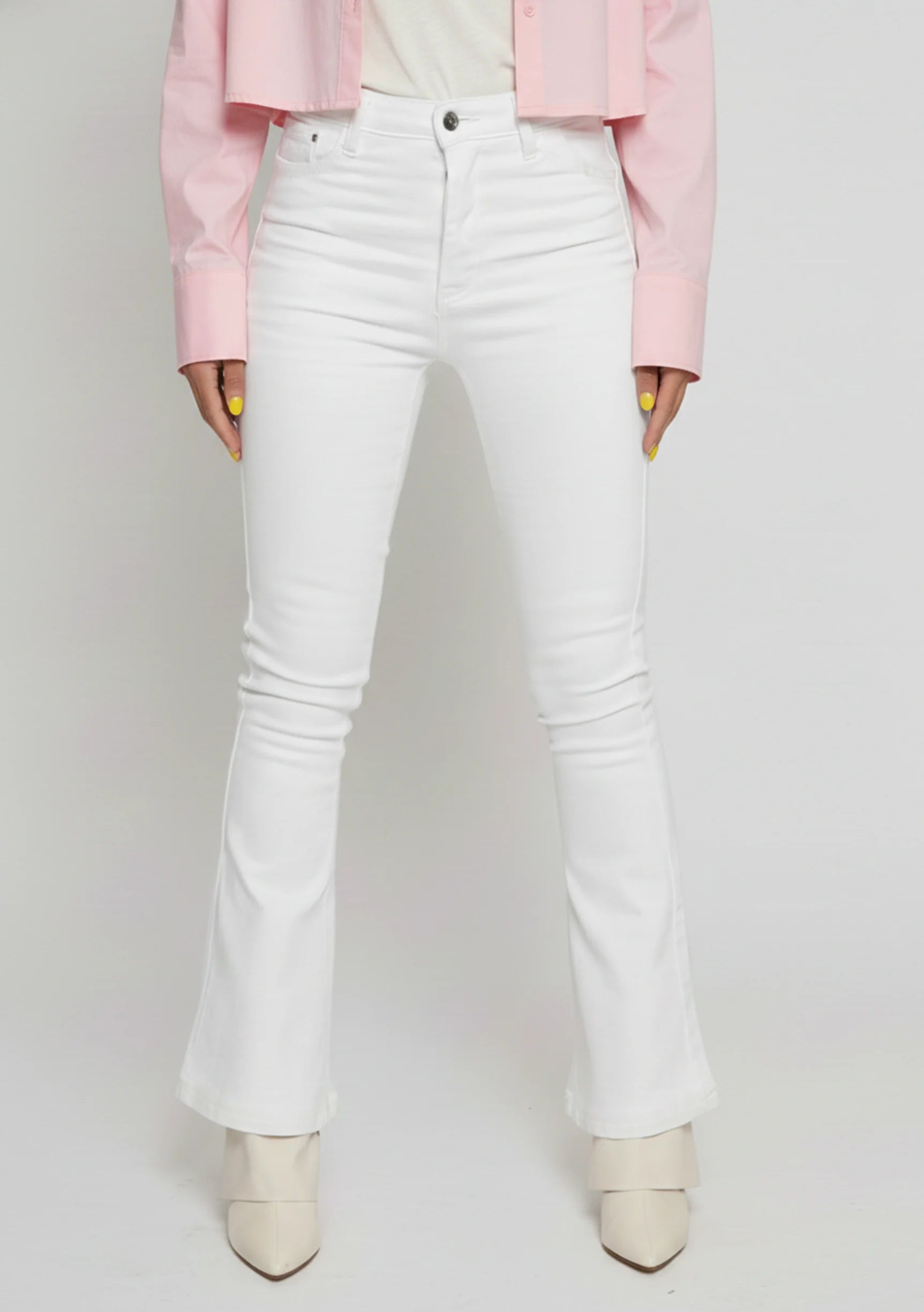 Close up of the front pockets, button closure, and high waist on white jeans