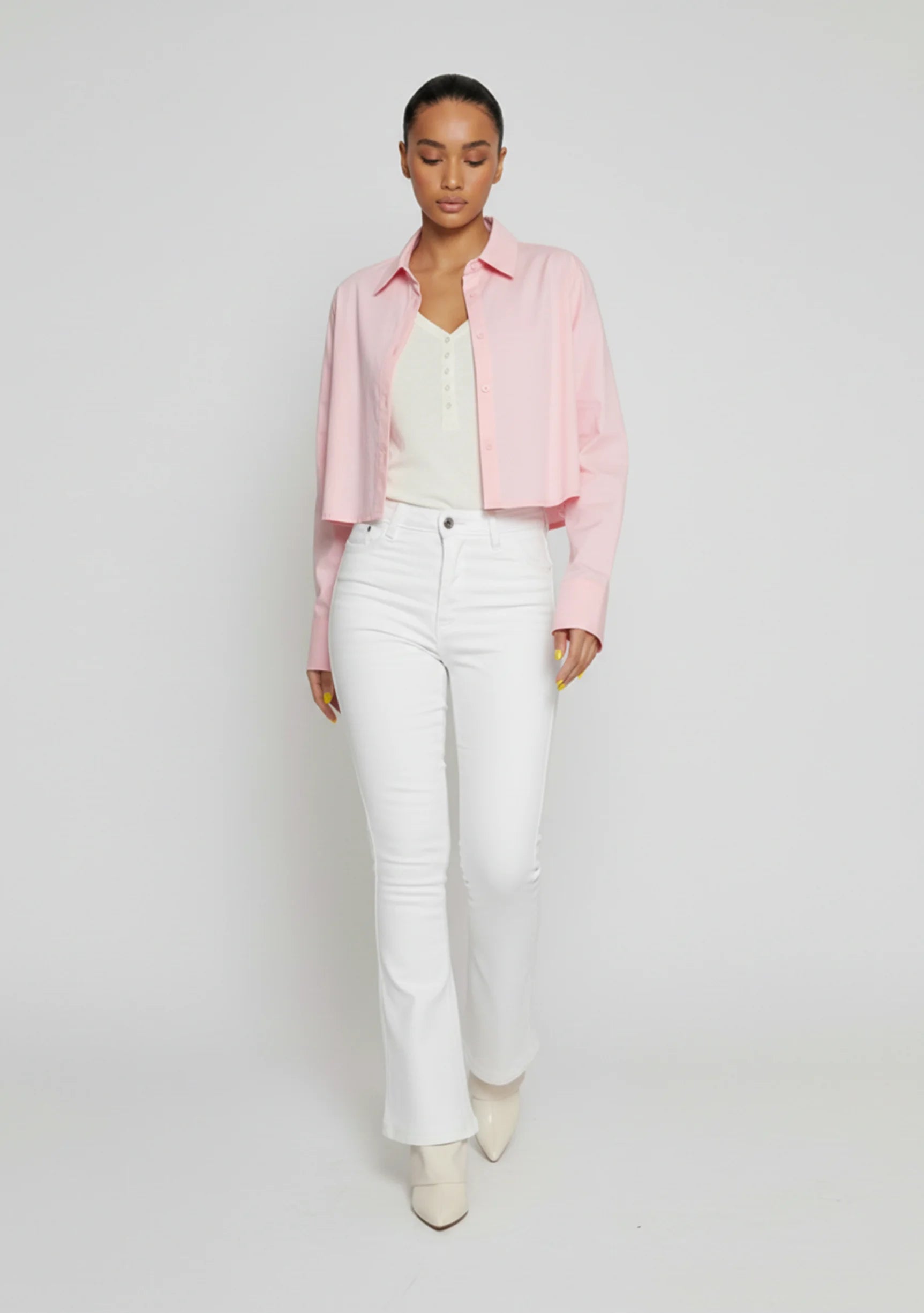 Front walking pose showing the fit and drape of white high-waisted jeans