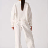 Rear view of a relaxed fit white cotton jumper showing the clean design