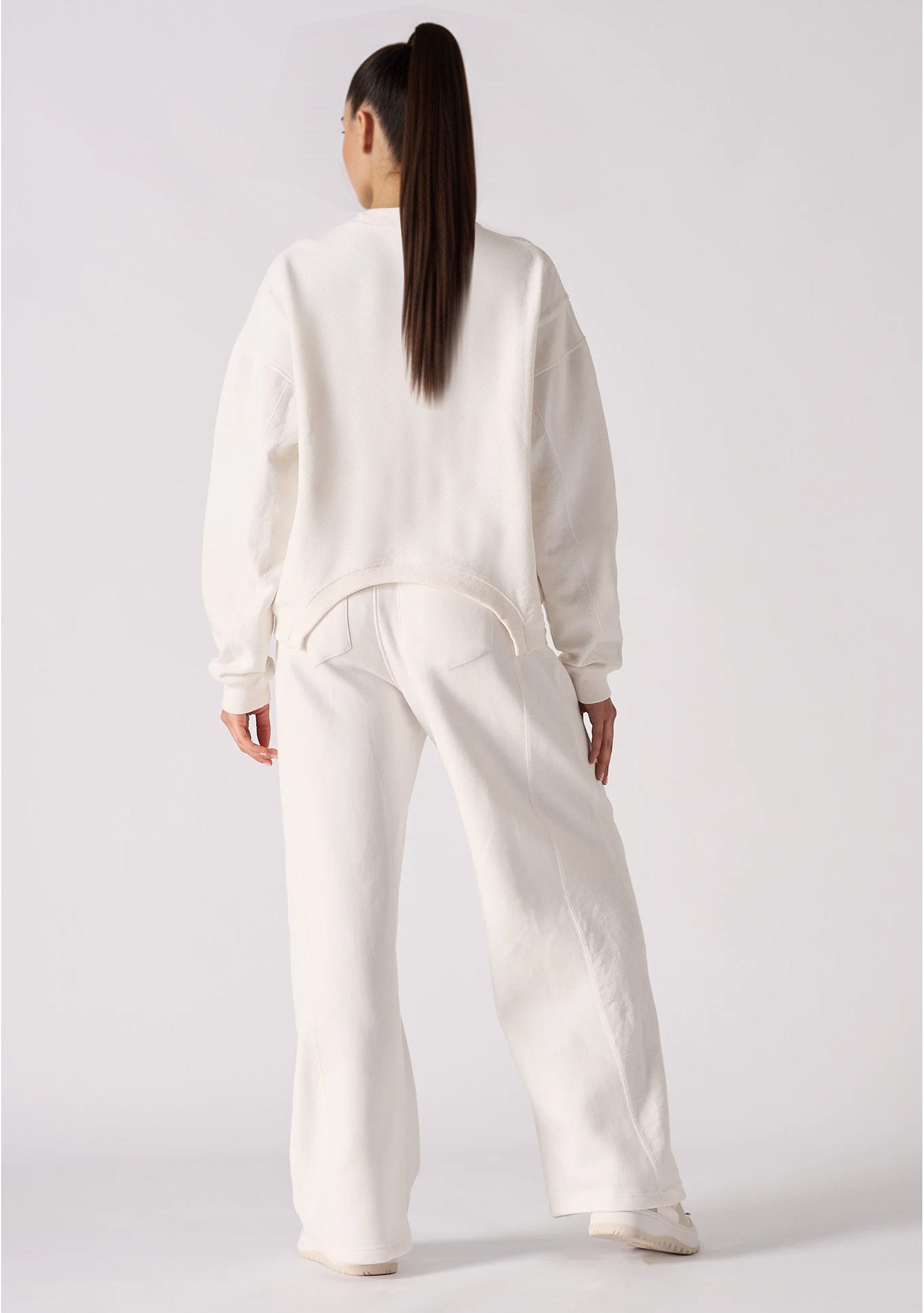 Rear view of a relaxed fit white cotton jumper showing the clean design