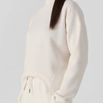 A woman walking while wearing a comfortable white cotton jumper