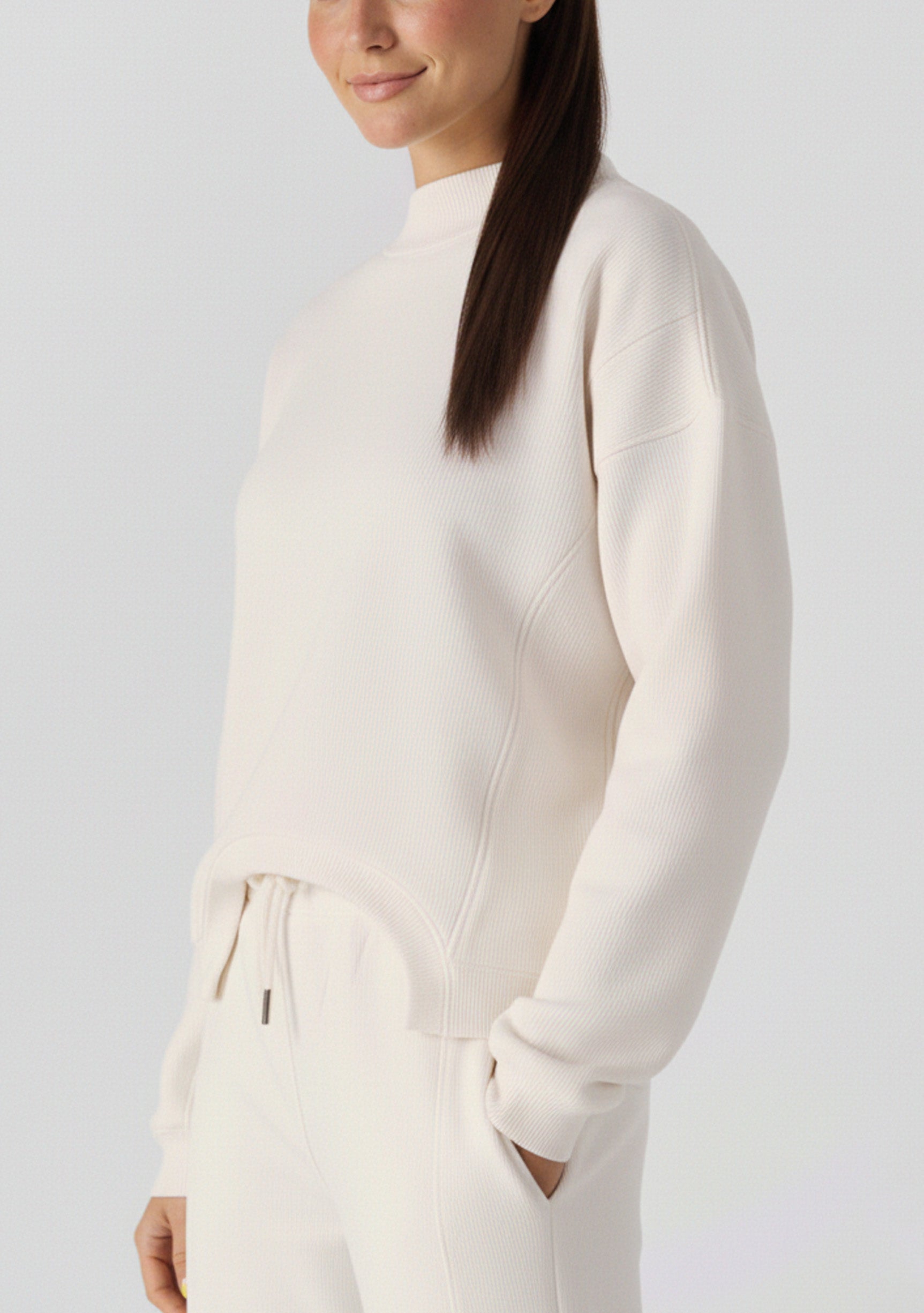 A woman walking while wearing a comfortable white cotton jumper