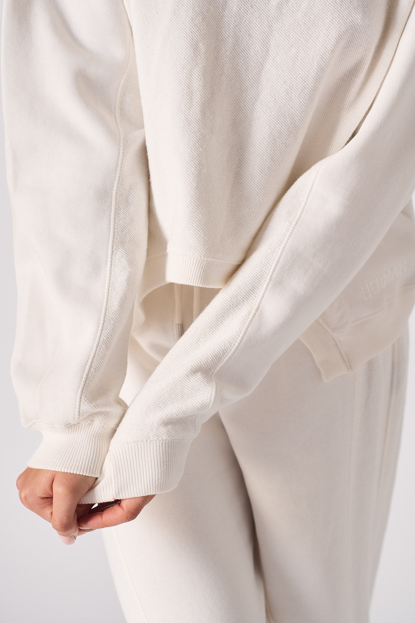 Close up of the ribbed cuff and soft fabric on a white cotton jumper