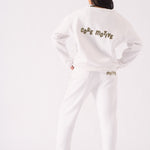 The back of a white crew neck jumper featuring bold graphic text and a relaxed fit