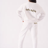 The back of a white crew neck jumper featuring bold graphic text and a relaxed fit
