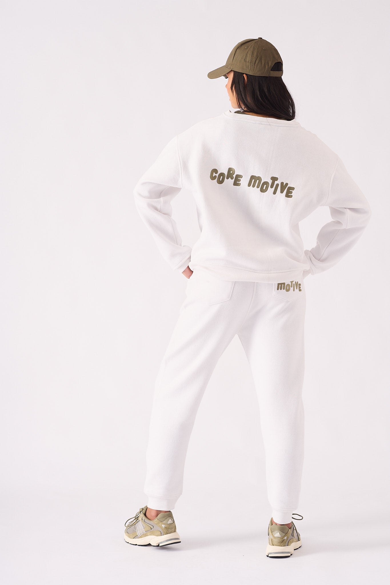 The back of a white crew neck jumper featuring bold graphic text and a relaxed fit