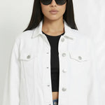 Close up of white denim jacket showing silver buttons, chest pockets, and classic collar detail
