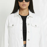 Close up of white denim jacket showing silver buttons, chest pockets, and classic collar detail