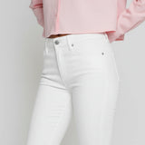Studio shot of model standing straight in women's white bootcut denim jeans
