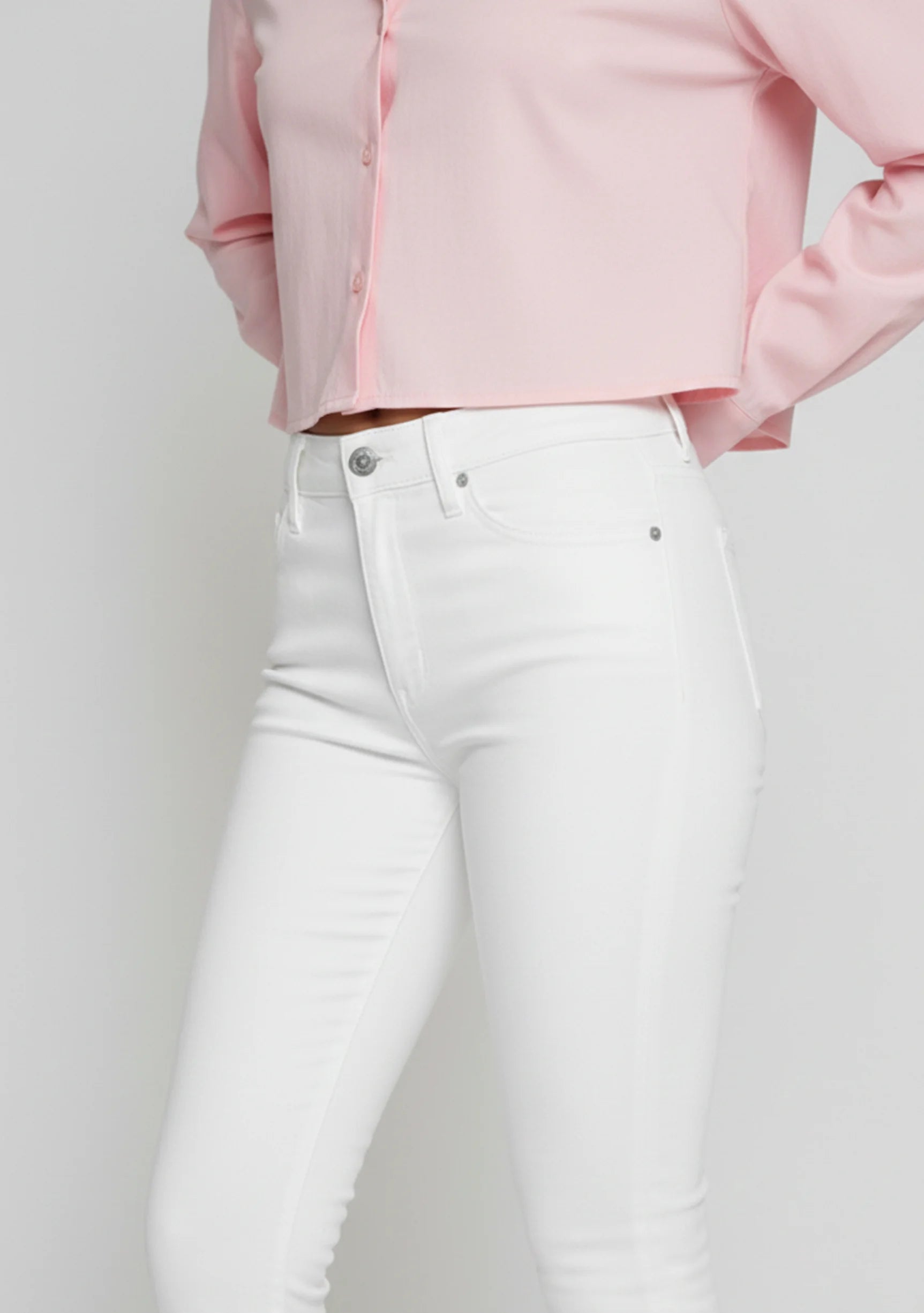 Studio shot of model standing straight in women's white bootcut denim jeans