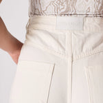 Close-up detail of the rear waistband construction and belt loops on white denim.