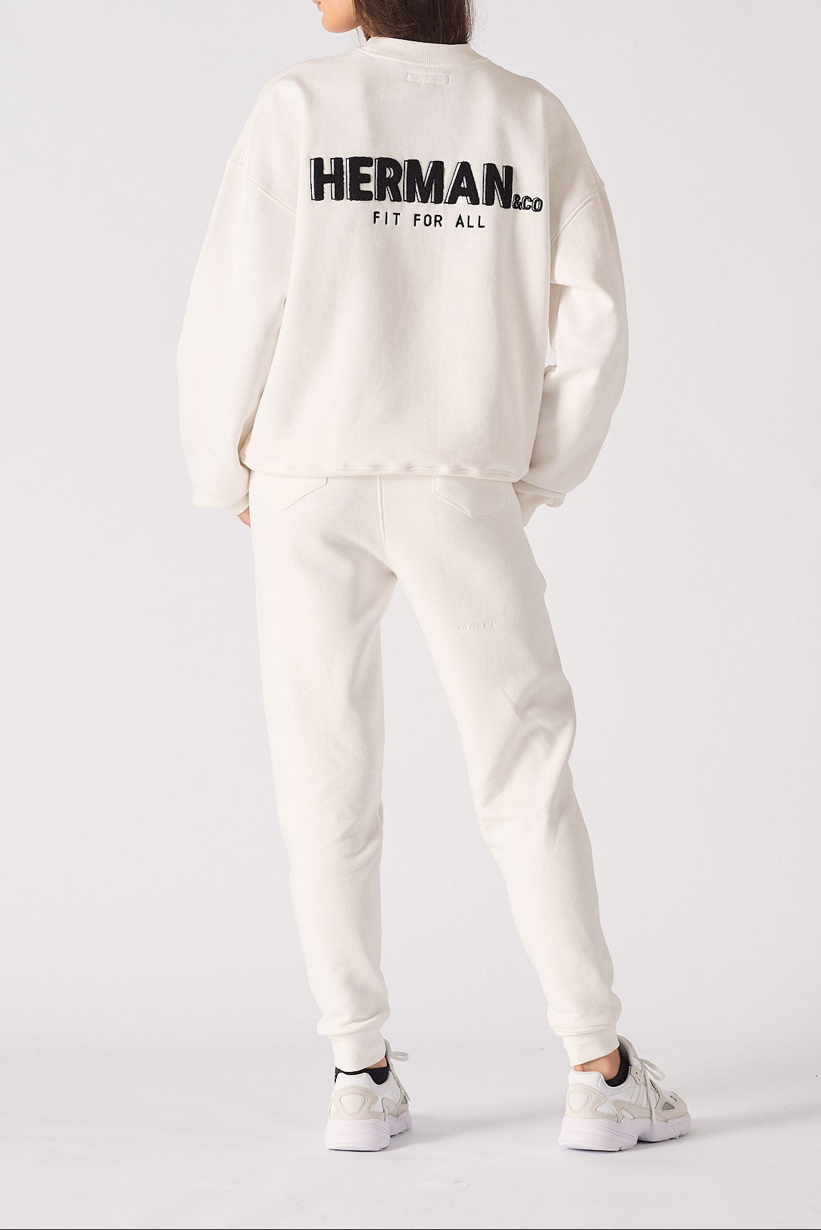 Rear view of a white sweatshirt for women showing the large black branding
