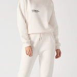 A woman wearing a white sweatshirt for women with matching joggers