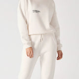 A woman wearing a white sweatshirt for women with matching joggers