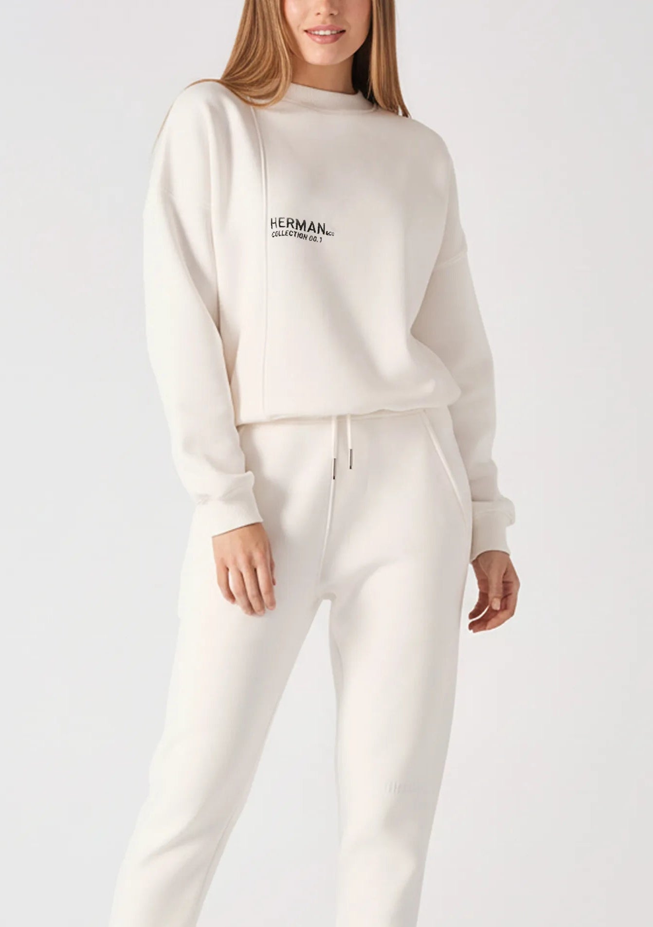 A woman wearing a white sweatshirt for women with matching joggers