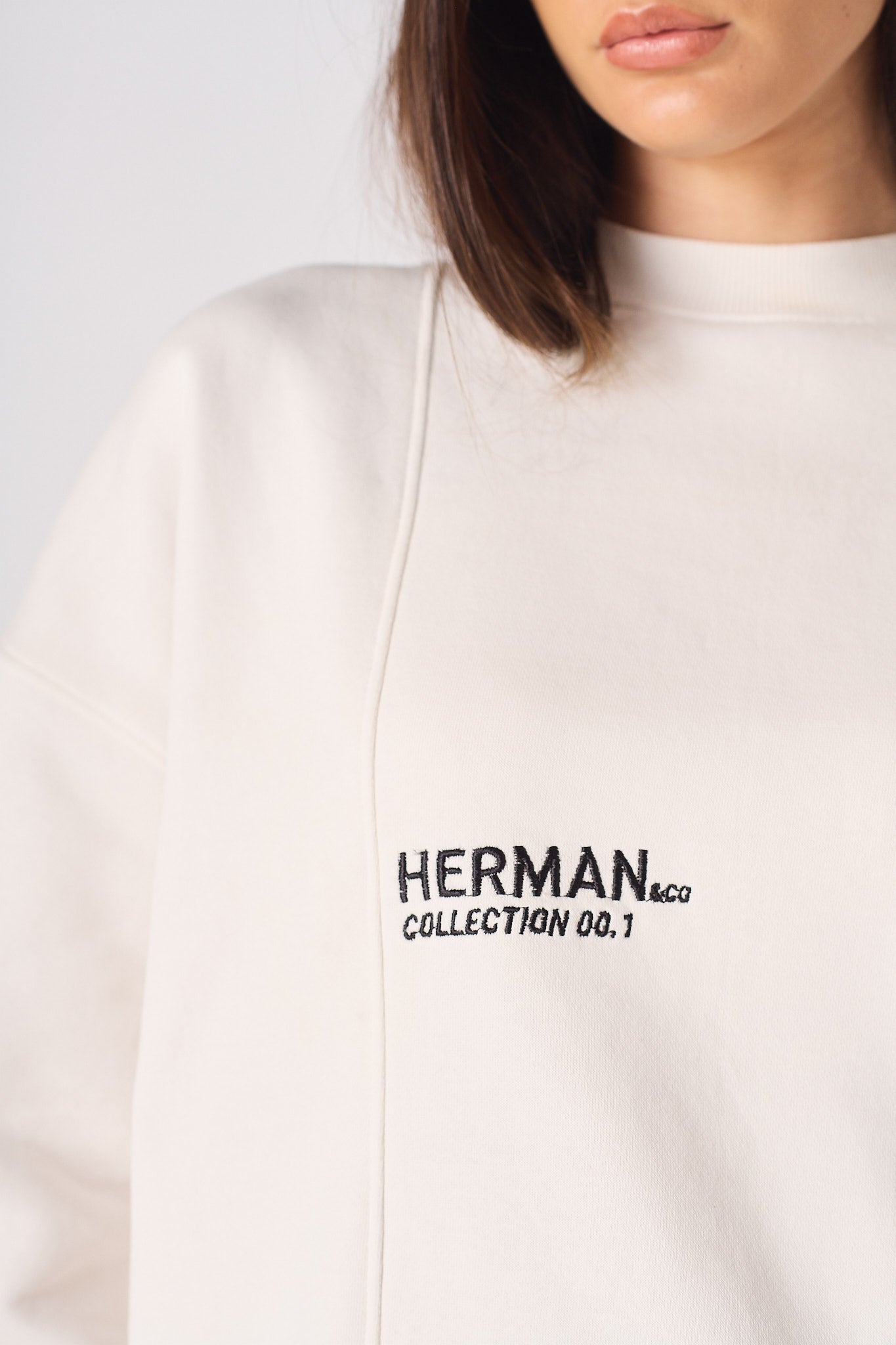 Detailed shot of the embroidered logo on a white sweatshirt for women