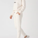 Side view of a woman walking in a relaxed white sweatshirt for women