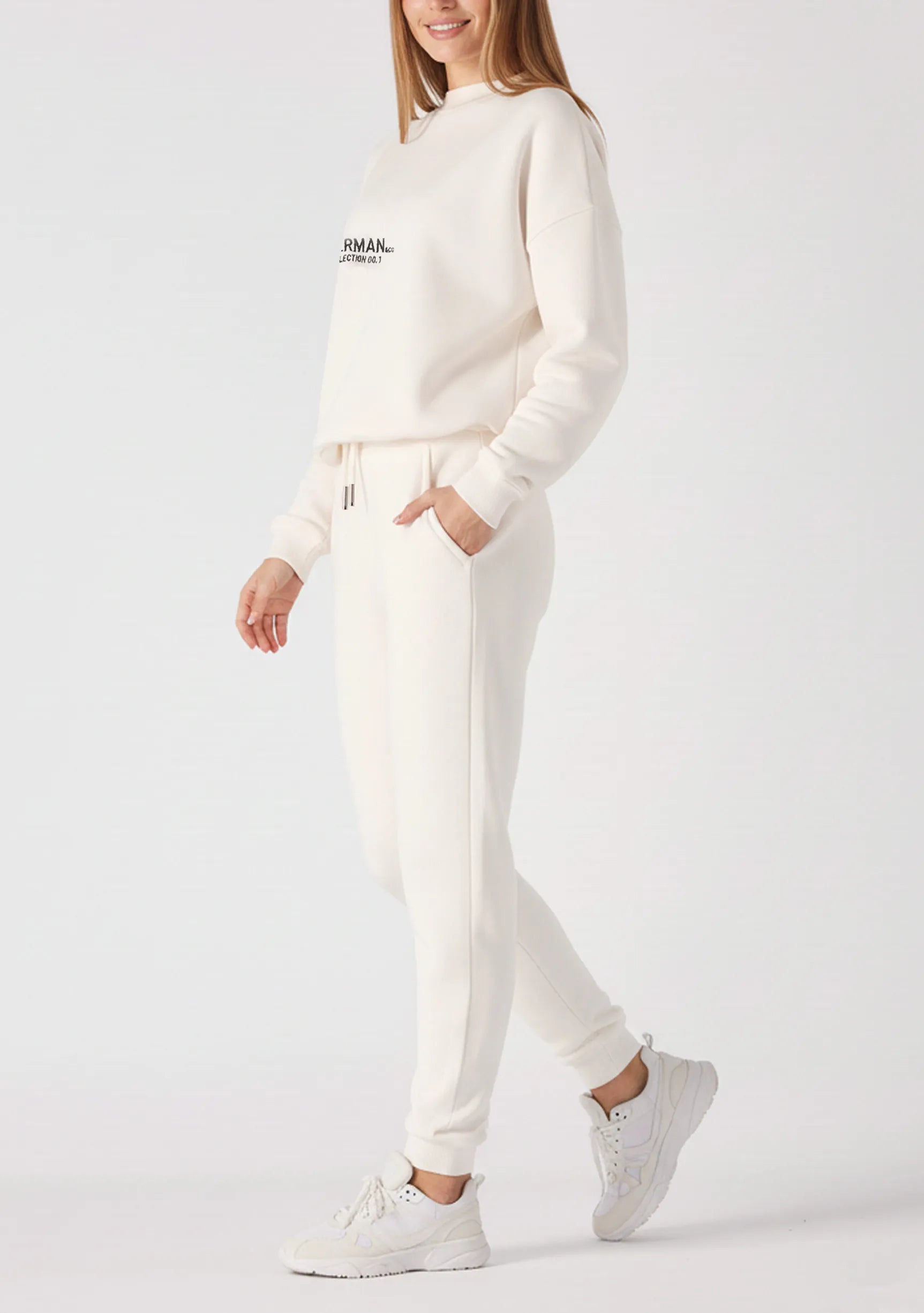 Side view of a woman walking in a relaxed white sweatshirt for women